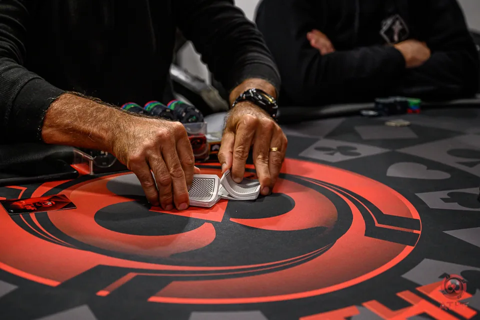 Dealer distribuindo as cartas sobre o logo da ATHF